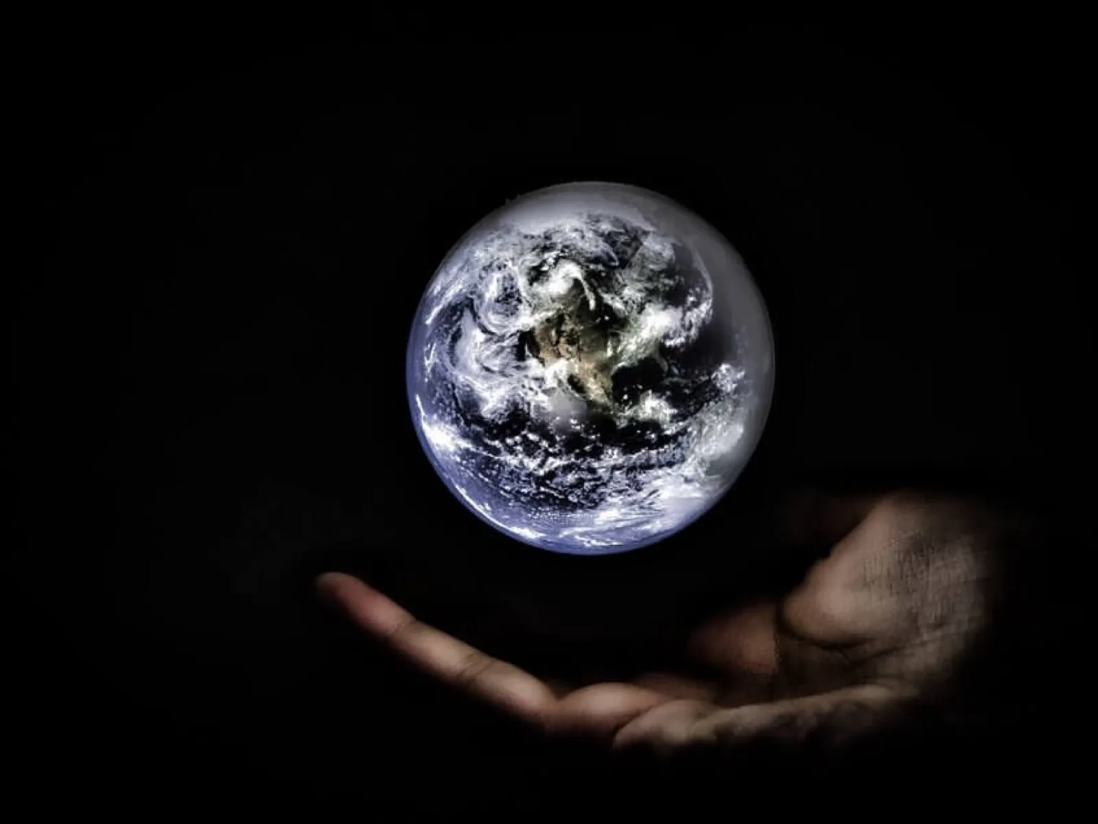 Planet Earth glowing above an open hand, illustrating the worldwide coverage reach of iPTT push-to-talk over cellular